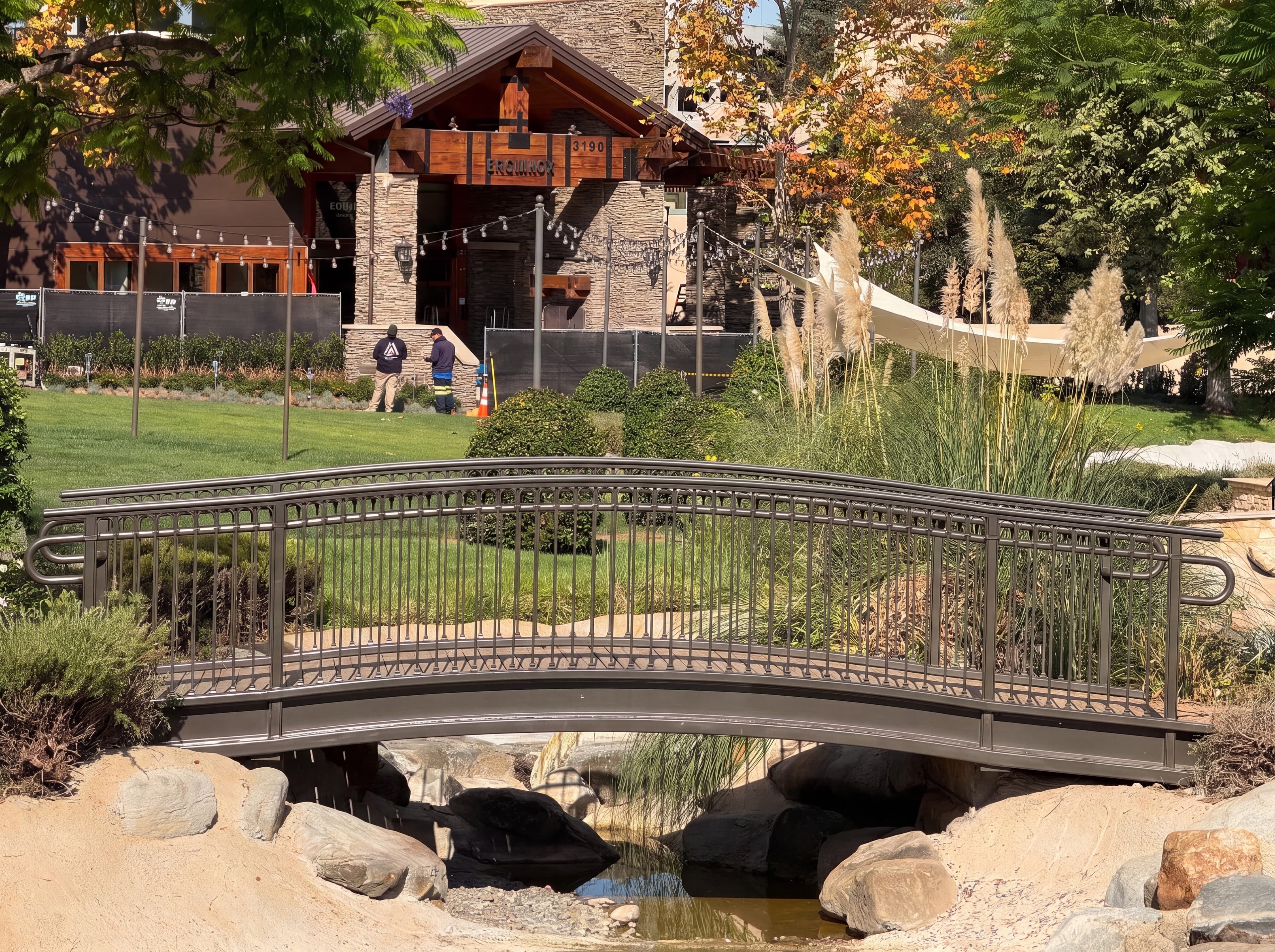 Arched Steel Pedestrian Bridge Over Water Feature